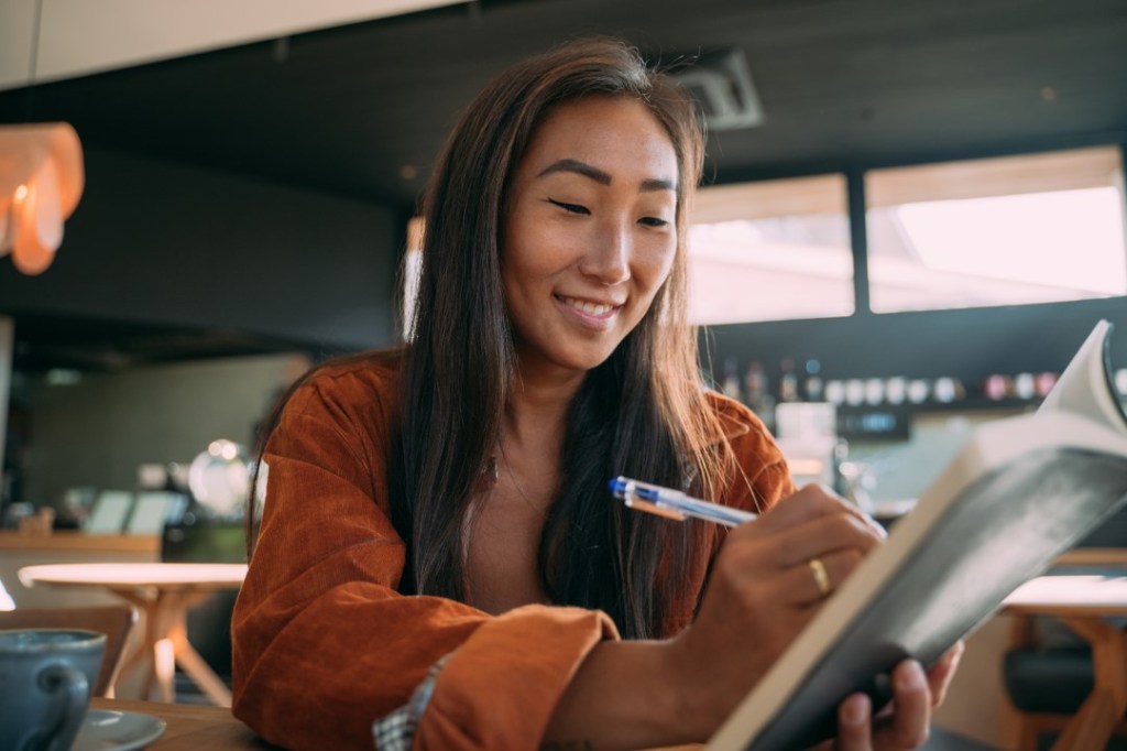 Woman writing on a notepad.
