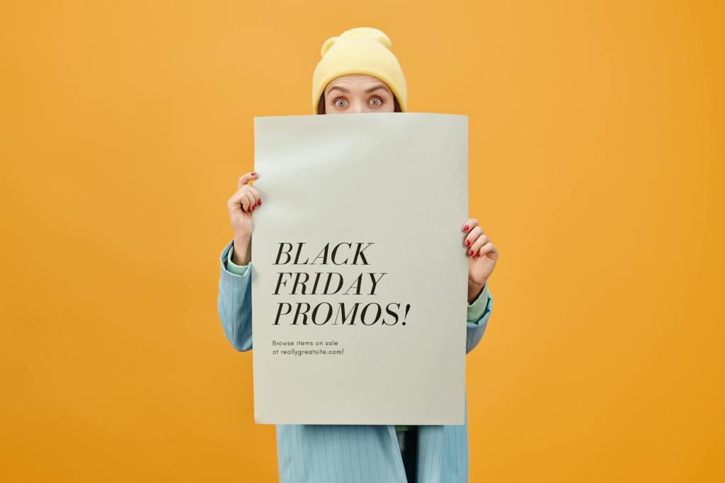 A woman holding a "black Friday promos" sign.